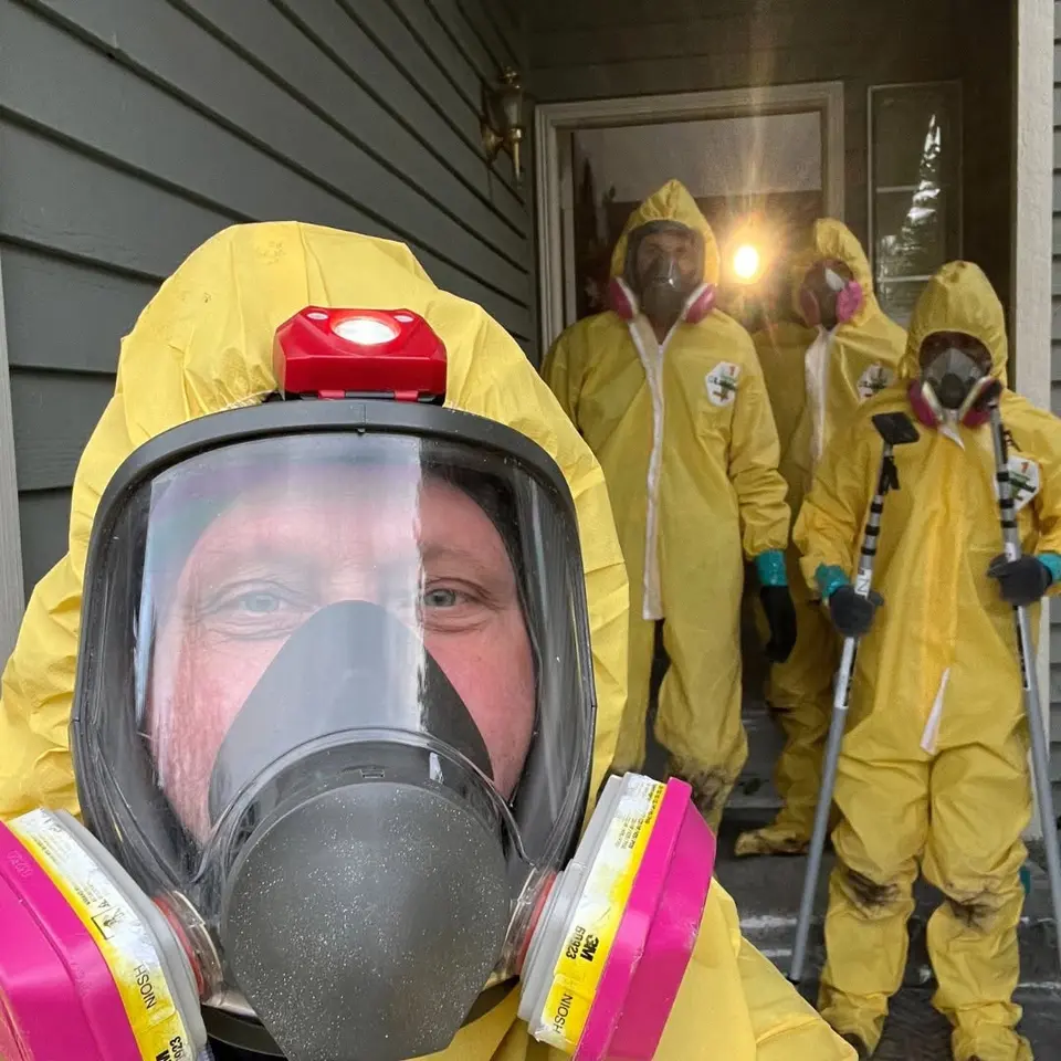 Restoration crew in protective coveralls preparing for crawlspace work